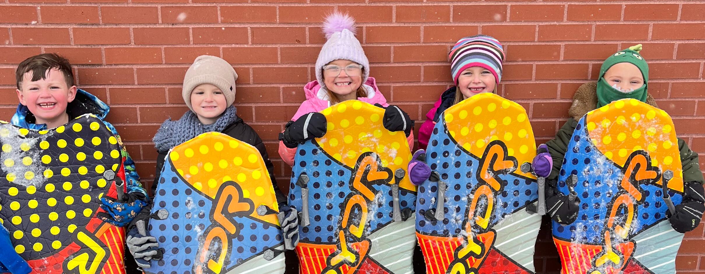 students using sleds during the winter